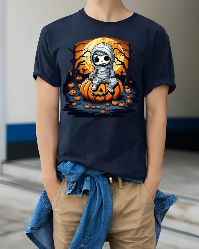 Cute Baby Mummy Sitting on Pumpkin Halloween T-shirt - model wearing navy shirt, hands in pockets