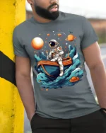 Astronaut Rowing Boat Space Adventure Graphic T-shirt - model in grey shirt leaning against column