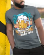 Stay Calm and Drink Beer T-Shirt Tropical Party Tee - model in grey shirt leaning against column