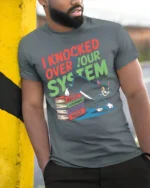 Funny Cat I Knocked Over Your System T-Shirt - model in grey shirt leaning against column