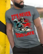 It’s Never Too Late Skeleton Surfer Graphic T-Shirt - model in grey shirt leaning against column