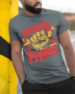 Power To The People Raised Fist Graphic T-Shirt - model in grey shirt leaning against column