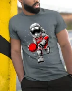 Astronaut Basketball Cosmic Dribble Graphic T-Shirt - model in grey shirt leaning against column