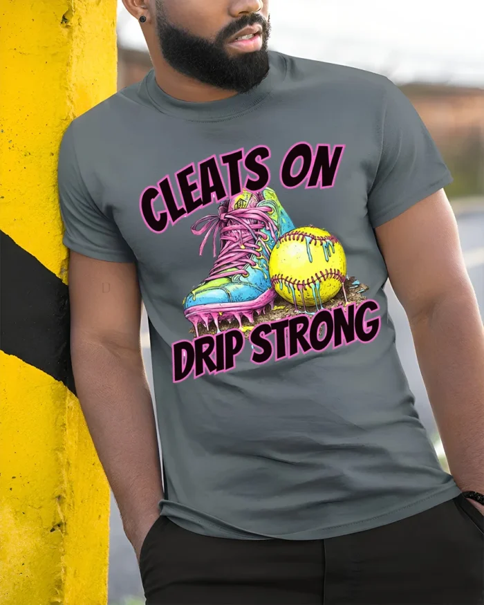 Cleats On Drip Strong Softball Graphic T-Shirt Black - model in grey shirt leaning against column
