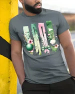 Floral Golf Ball and Club Art Graphic T-Shirt - model in grey shirt leaning against column