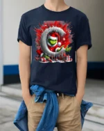 Mischief Green Santa Christmas Naughty Graphic Tshirt - model wearing navy shirt, hands in pockets