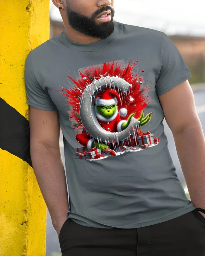 Mischief Green Santa Christmas Naughty Graphic Tshirt - model in grey shirt leaning against column
