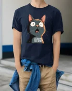Funny Shocked Cat Graphic T Shirt Viral Meme Tee - model wearing navy tee with hands in pockets