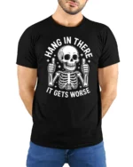 Hang In There It Gets Worse Funny Skeleton Dark Humor T Shirt - model wearing black tee with hands behind back