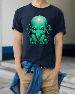 Cute Cthulhu Monster T Shirt Adorable Lovecraft Inspired Cartoon Graphic - model wearing navy tee with hands in pockets