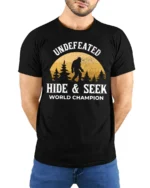Undefeated Hide And Seek World Champion Bigfoot Funny Sasquatch T Shirt - model wearing black tee with hands behind back