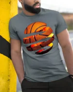 Torn Basketball Explosion T Shirt Fiery Slam Dunk Sports Graphic - model wearing grey tee, leaning on column