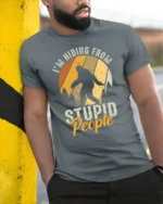 Funny Bigfoot Im Hiding From Stupid People Vintage T Shirt - model wearing grey tee, leaning on column
