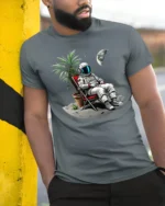Funny Relaxing Astronaut On The Moon Vacation Graphic T Shirt - model wearing grey tee, leaning on column