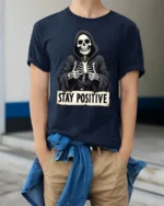 Funny Stay Positive Skeleton Thumbs Up Graphic T Shirt - model wearing navy tee with hands in pockets