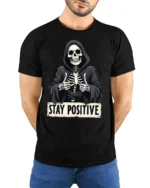 Funny Stay Positive Skeleton Thumbs Up Graphic T Shirt - model wearing black tee with hands behind back