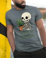 Funny Trying To Stay Alive Skeleton Plant Graphic T Shirt - model wearing grey tee, leaning on column