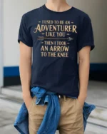 Funny I Used To Be An Adventurer Arrow Knee T Shirt - model wearing navy tee with hands in pockets
