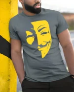 Anonymous Mask Graphic T Shirt Hacker Style Face Tee - model wearing grey tee, leaning on column