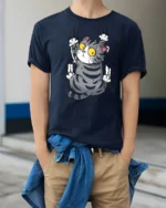 Silly Climbing Cat Wide Eyes Cute Cartoon Graphic Tee Shirt - model wearing navy tee with hands in pockets