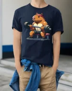 Strong Capybara Gym Lover Funny Fitness Graphic T Shirt - model wearing navy tee with hands in pockets