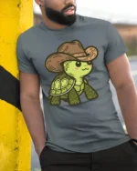 Cute Cowboy Turtle Graphic T Shirt Funny Western Animal Style Tee - model wearing grey tee, leaning on column