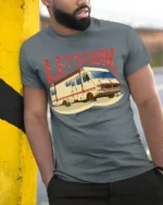 Lets Cook RV Camper Graphic T Shirt Funny Vintage Road Trip Style - model wearing grey tee, leaning on column