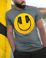 Smiley Face Headphones Graphic T Shirt Retro Music Vibe Tee - model wearing grey tee, leaning on column