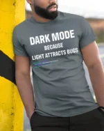 Dark Mode Because Light Attracts Bugs Funny Coding T Shirt Geek Tee - model wearing grey tee, leaning on column