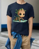Cute Tree Baby Surfing Cartoon Graphic T Shirt - model wearing navy tee with hands in pockets