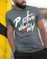 Positive Vibes Only Bold Script Motivational T Shirt - model wearing grey tee, leaning on column