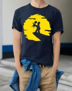 Cute Father And Child Sunset Moment Cartoon Graphic T Shirt - model wearing navy tee with hands in pockets