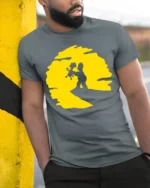 Cute Father And Child Sunset Moment Cartoon Graphic T Shirt - model wearing grey tee, leaning on column