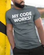 My Code Works I Have No Idea Why Funny Dev T Shirt - model wearing grey tee, leaning on column