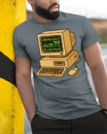 Retro Computer Oregon Trail Style Vintage Gamer T Shirt - model wearing grey tee, leaning on column
