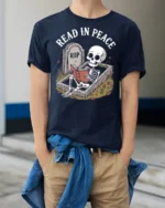 Funny Read In Peace Skeleton Graphic T Shirt Book Lover Humor - model wearing navy tee with hands in pockets