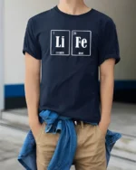 LiFe Chemistry Pun Lithium Iron Periodic Table Funny T Shirt - model wearing navy tee with hands in pockets