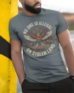 No One Is Illegal On Stolen Land Bold Statement Graphic T Shirt - model wearing grey tee, leaning on column