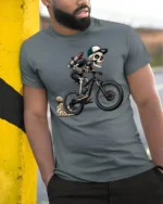 Cool Skeleton Riding Bike Graphic T Shirt Gothic Sport Style Tee - model wearing grey tee, leaning on column