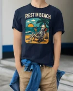 Rest In Beach Funny Skeleton Vacation Graphic Tee Tshirt - model wearing navy tee with hands in pockets