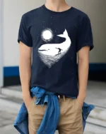 Cosmic Whale Surf Graphic Tee Dreamy Ocean Night Tshirt - model wearing navy tee with hands in pockets