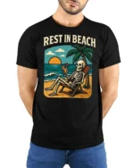 Rest In Beach Funny Skeleton Vacation Graphic Tee Tshirt - model wearing black tee with hands behind back