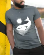 Cosmic Whale Surf Graphic Tee Dreamy Ocean Night Tshirt - model wearing grey tee, leaning on column