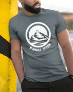 Wander Often Mountain Adventure Graphic Tee Outdoor Tshirt - model wearing grey tee, leaning on column