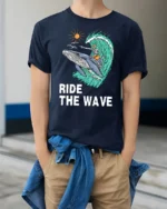 Ride The Wave Skeleton Surfing Whale Tshirt Ocean Humor - model wearing navy tee with hands in pockets