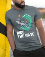 Ride The Wave Skeleton Surfing Whale Tshirt Ocean Humor - model wearing grey tee, leaning on column