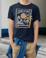 Sunshine And Surf Retro Beach Graphic Tshirt Summer Vibes Style - model wearing navy tee with hands in pockets