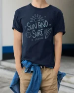 Sun And Surf Beach Graphic Tshirt Relaxed Summer Ocean Vibes Style - model wearing navy tee with hands in pockets