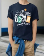 Summer Ocean Surfing Beach Graphic Tshirt Retro Coastal Vibes Style - model wearing navy tee with hands in pockets