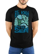 Be Kind To The Sea Graphic Tshirt Ocean Lover Coastal Style - model wearing black tee with hands behind back